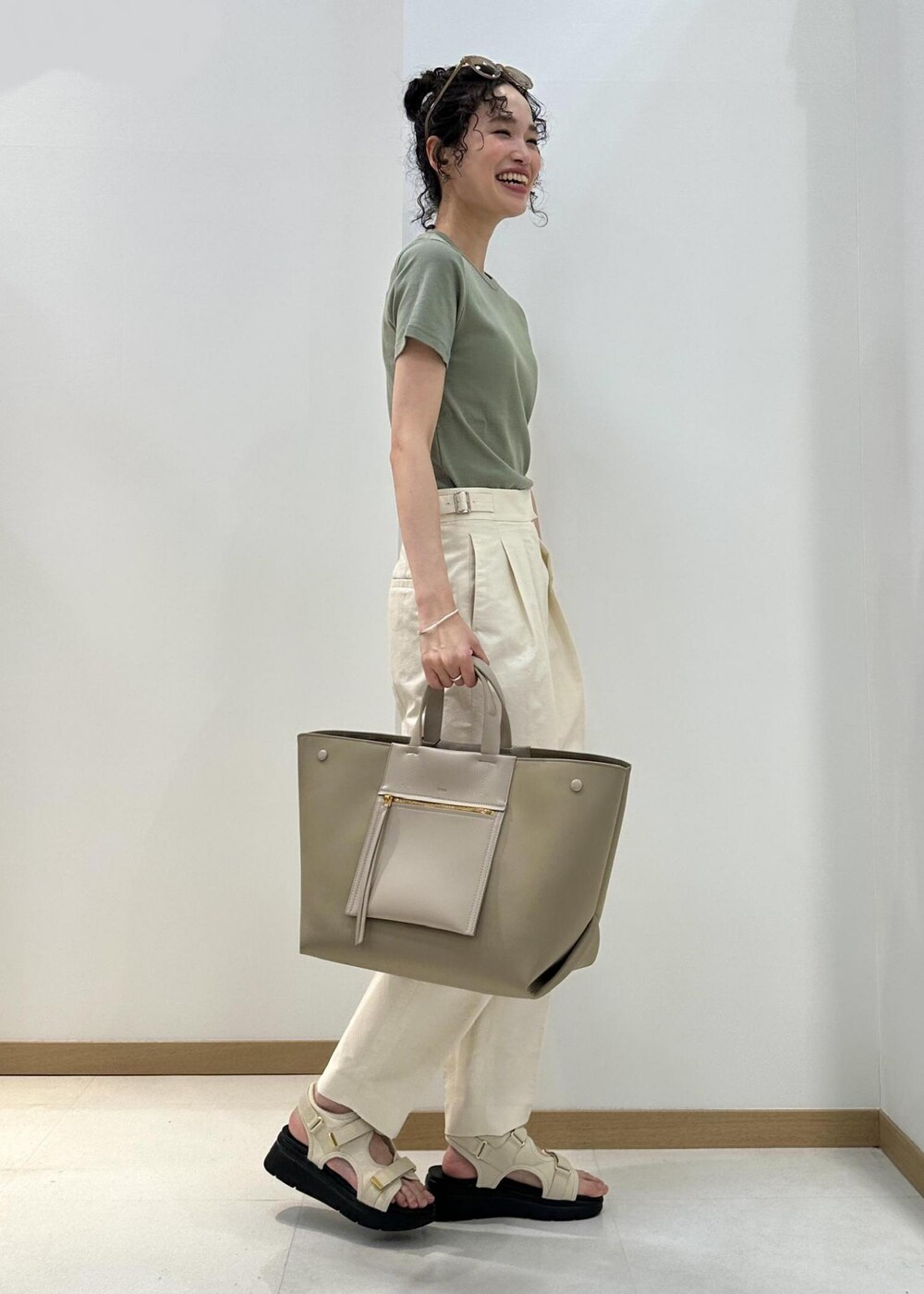 ホワイト系のその他パンツ、ベージュ系のハンドバッグ、ホワイト系のサンダルを着用したレディースの夏コーディネートの2枚目の写真