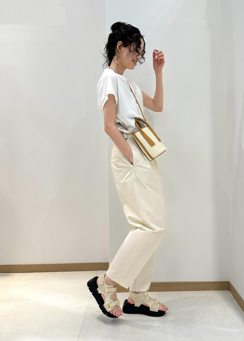 ホワイト系のTシャツ/カットソー、ベージュ系のハンドバッグ、ホワイト系のその他パンツを着用したレディースの夏コーディネートの2枚目の写真