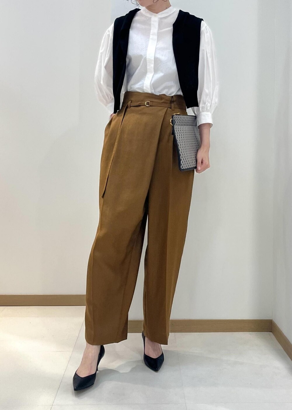 ブラック系のパンプス、ホワイト系のシャツ/ブラウス、ブラック系のカーディガン/ボレロを着用したレディースの春コーディネートの4枚目の写真