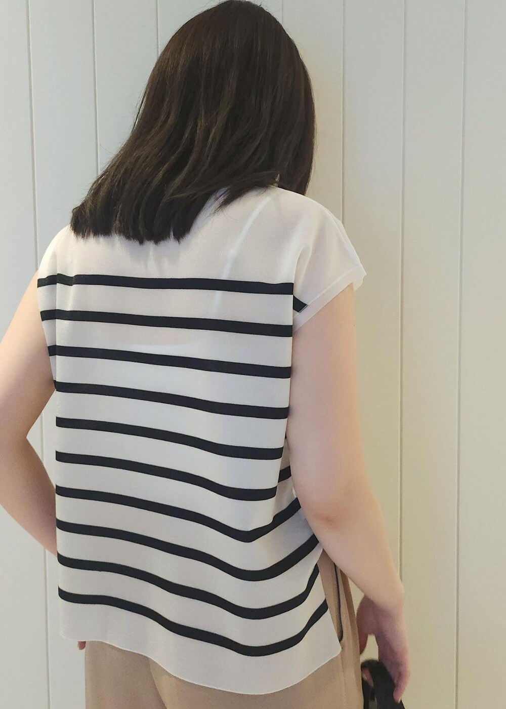 ブラック系のハンドバッグ、ベージュ系のその他パンツ、ブルー系のシャツ/ブラウスを着用したレディースの夏コーディネートの6枚目の写真