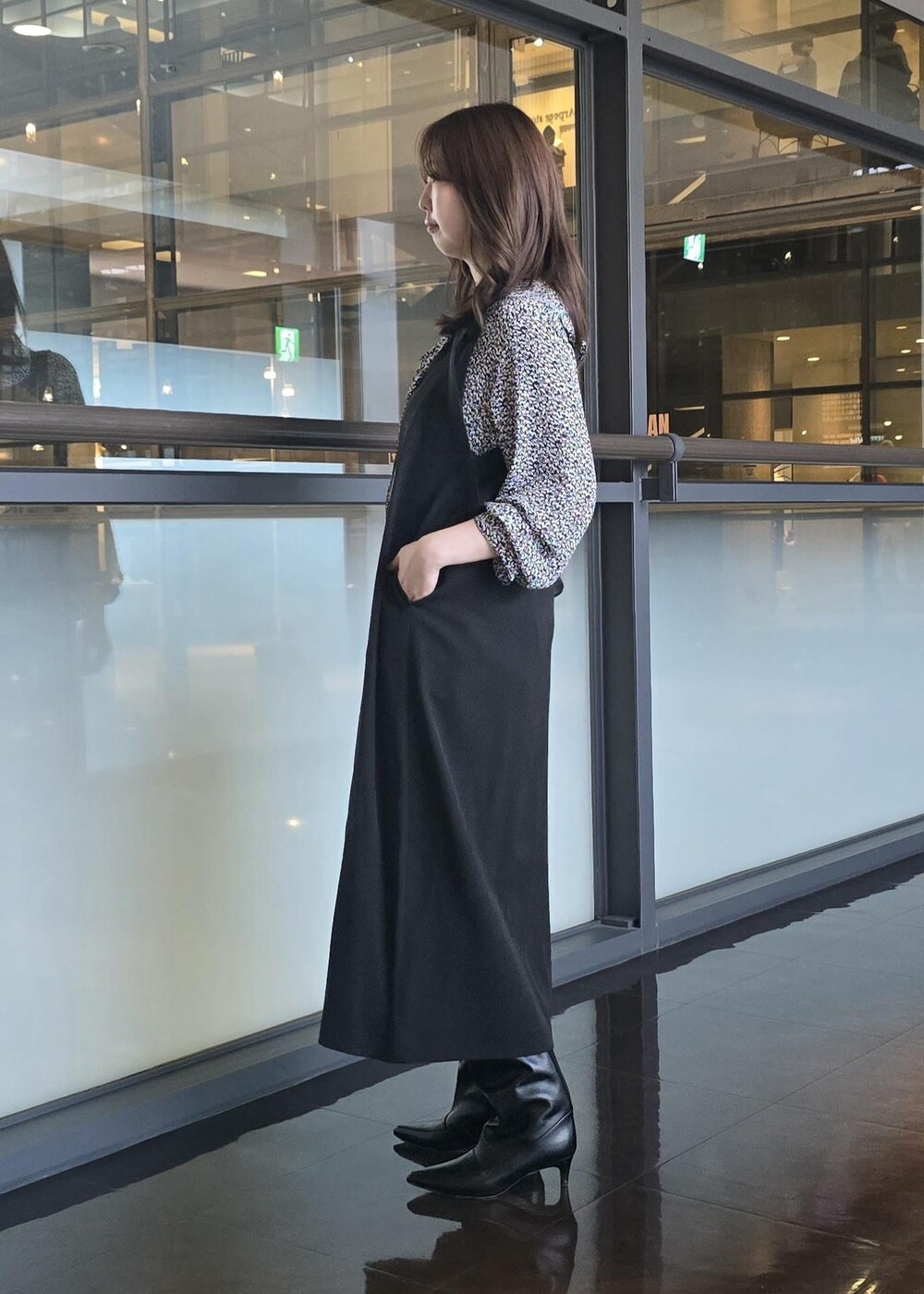 ブラック系のブーツ、ブラック系のハンドバッグ、ブルー系のシャツ/ブラウスを着用したレディースの秋コーディネートの2枚目の写真