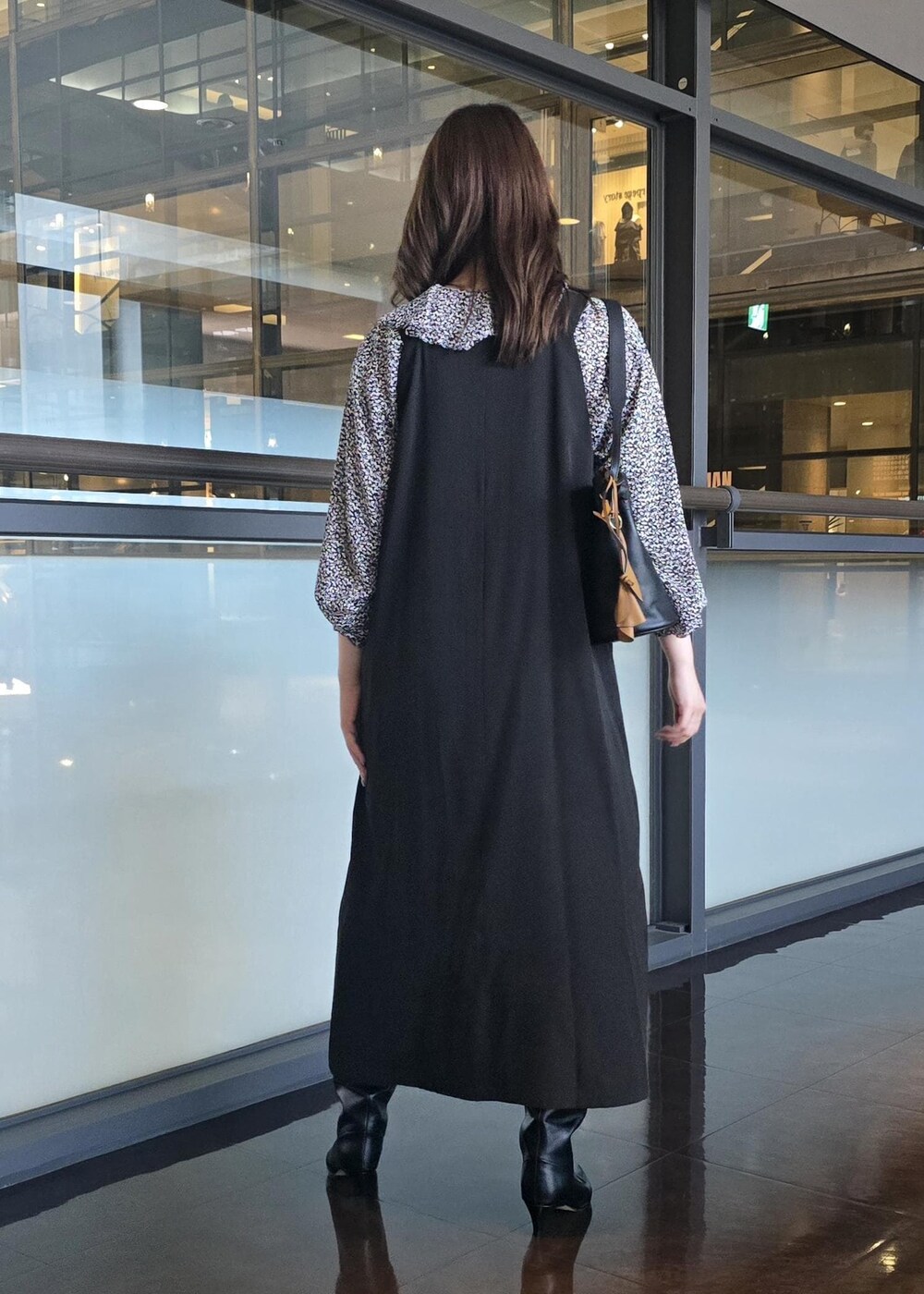 ブラック系のブーツ、ブラック系のハンドバッグ、ブルー系のシャツ/ブラウスを着用したレディースの秋コーディネートの3枚目の写真