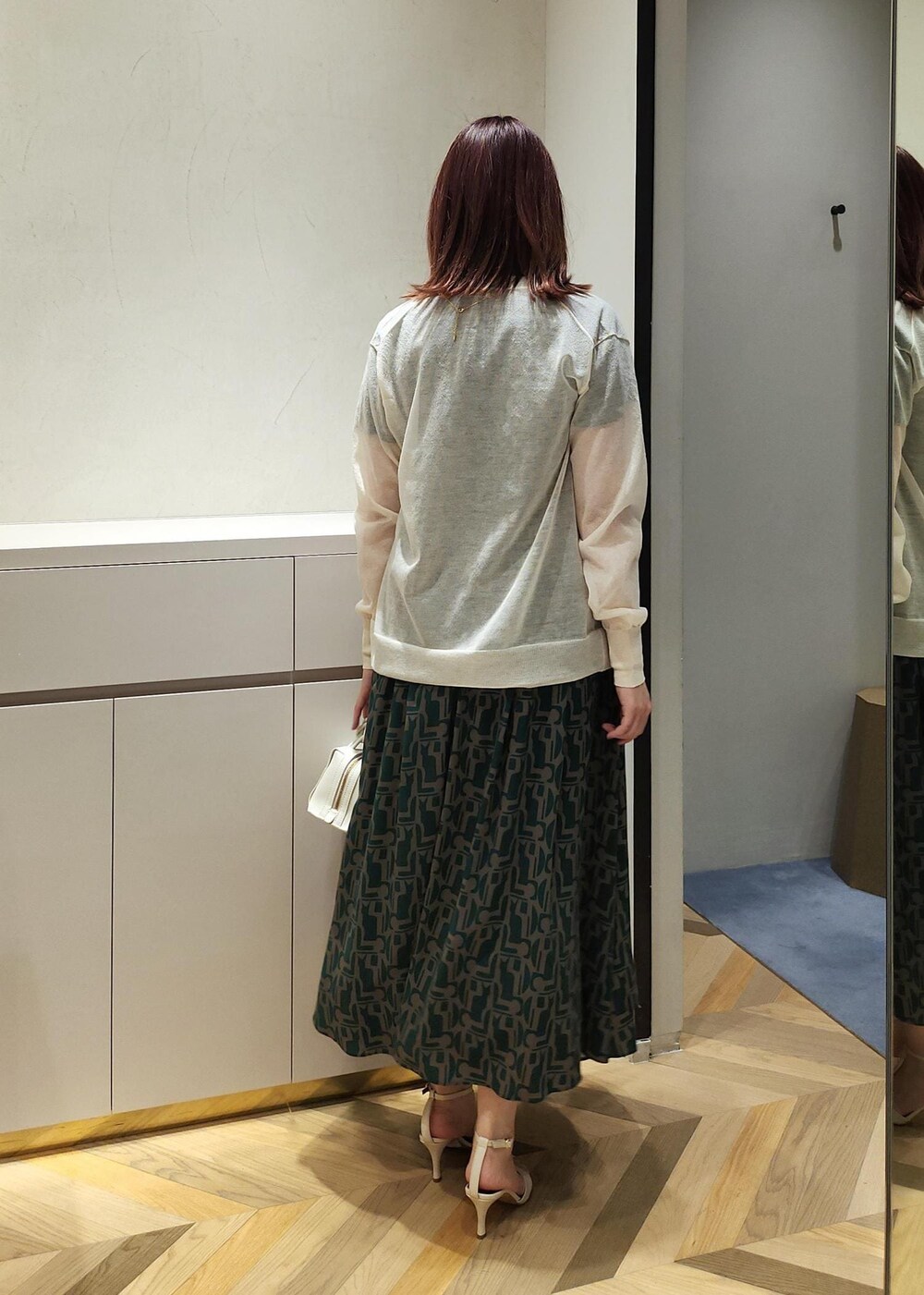 ホワイト系のサンダル、ホワイト系のショルダーバッグ、ホワイト系のカーディガン/ボレロを着用したレディースの春コーディネートの2枚目の写真