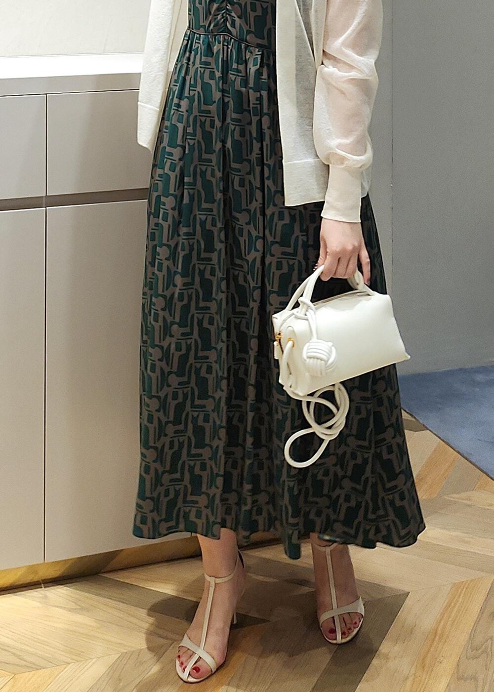 ホワイト系のサンダル、ホワイト系のショルダーバッグ、ホワイト系のカーディガン/ボレロを着用したレディースの春コーディネートの3枚目の写真