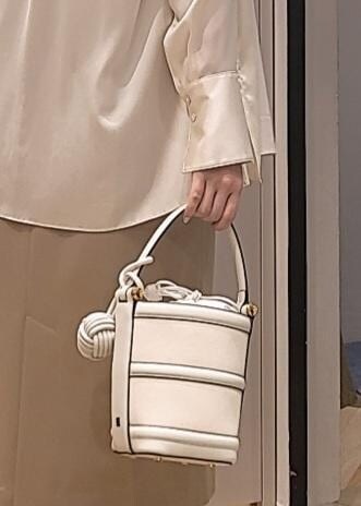 ホワイト系のハンドバッグ、ホワイト系のサンダル、ホワイト系のシャツ/ブラウスを着用したレディースの春コーディネートの6枚目の写真