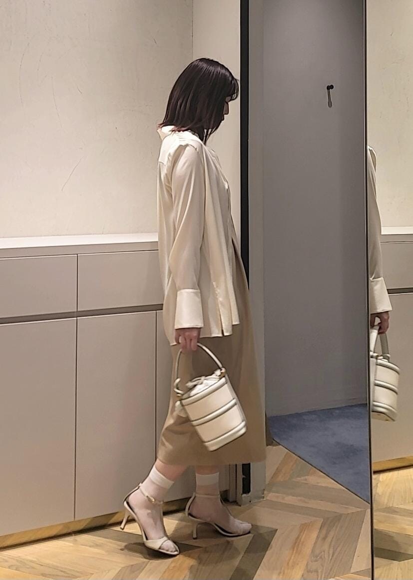 ホワイト系のハンドバッグ、ホワイト系のサンダル、ホワイト系のシャツ/ブラウスを着用したレディースの春コーディネートの2枚目の写真