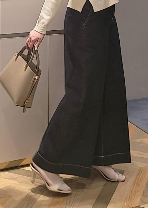 ベージュ系のハンドバッグ、ブルー系のデニムパンツ、ホワイト系のサンダルを着用したレディースの春コーディネートの4枚目の写真