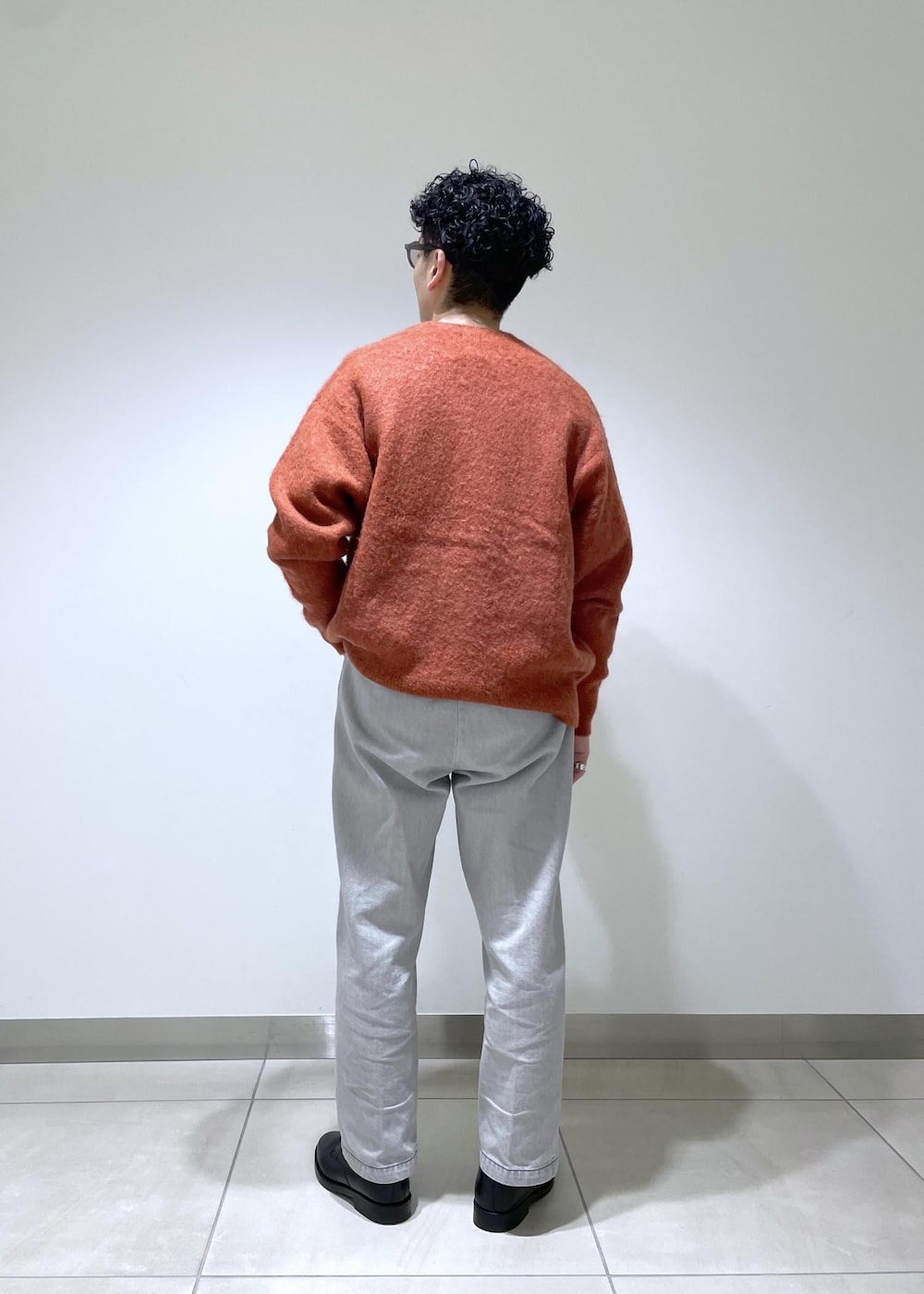 オレンジ系のカーディガン/ボレロを着用したメンズの冬コーディネートの3枚目の写真