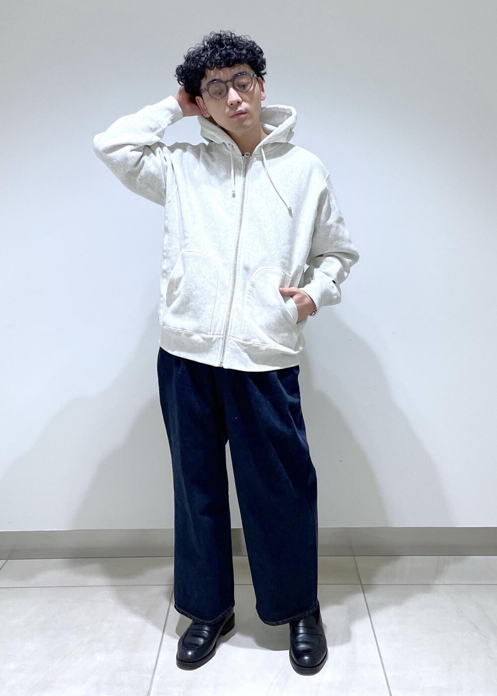 ホワイト系のパーカー、ブルー系のデニムパンツを着用したメンズの冬コーディネートの3枚目の写真