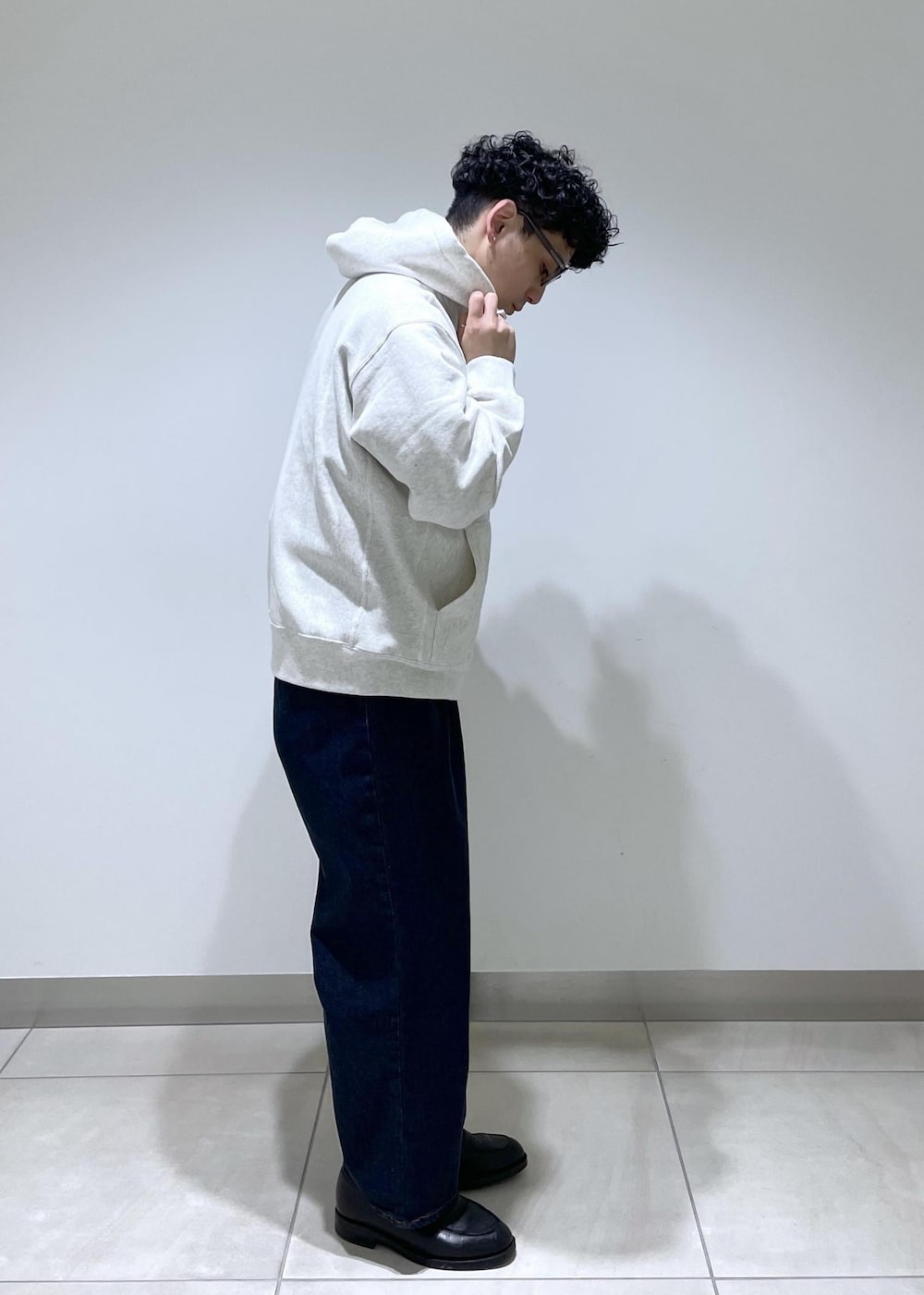 ホワイト系のパーカー、ブルー系のデニムパンツを着用したメンズの冬コーディネートの2枚目の写真