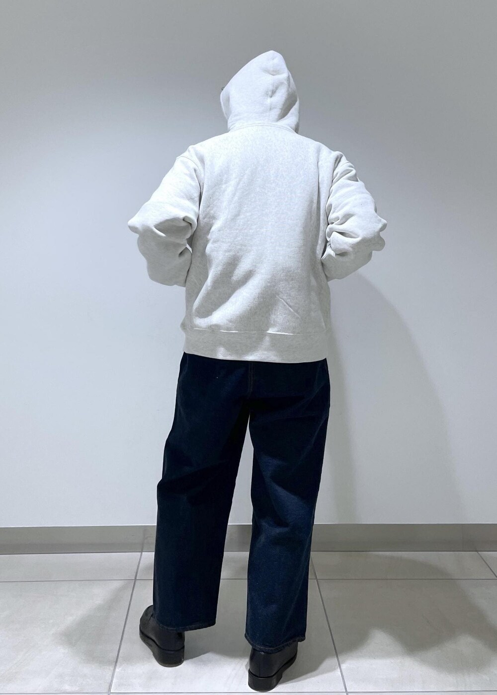 ホワイト系のパーカー、ブルー系のデニムパンツを着用したメンズの冬コーディネートの6枚目の写真