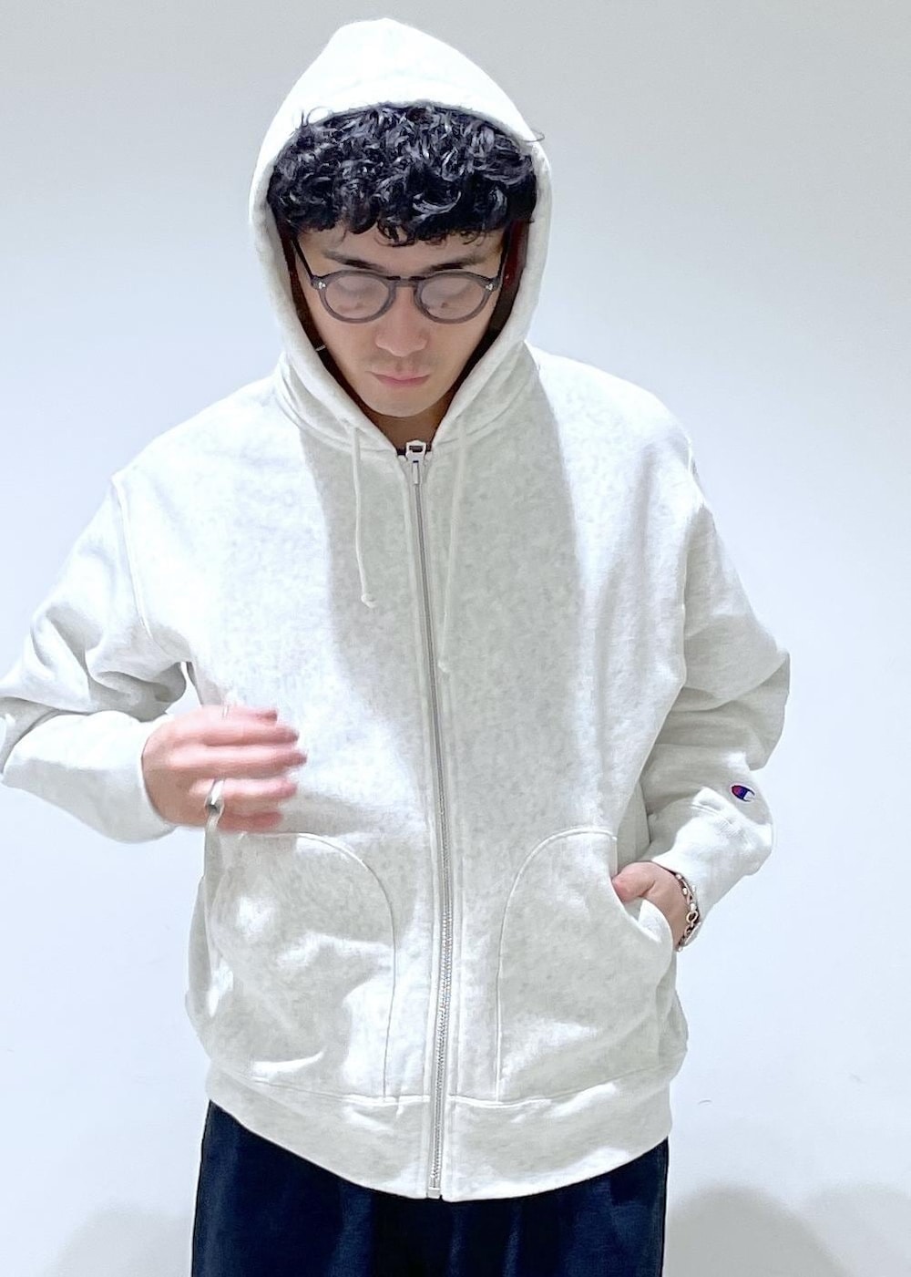 ホワイト系のパーカー、ブルー系のデニムパンツを着用したメンズの冬コーディネートの4枚目の写真