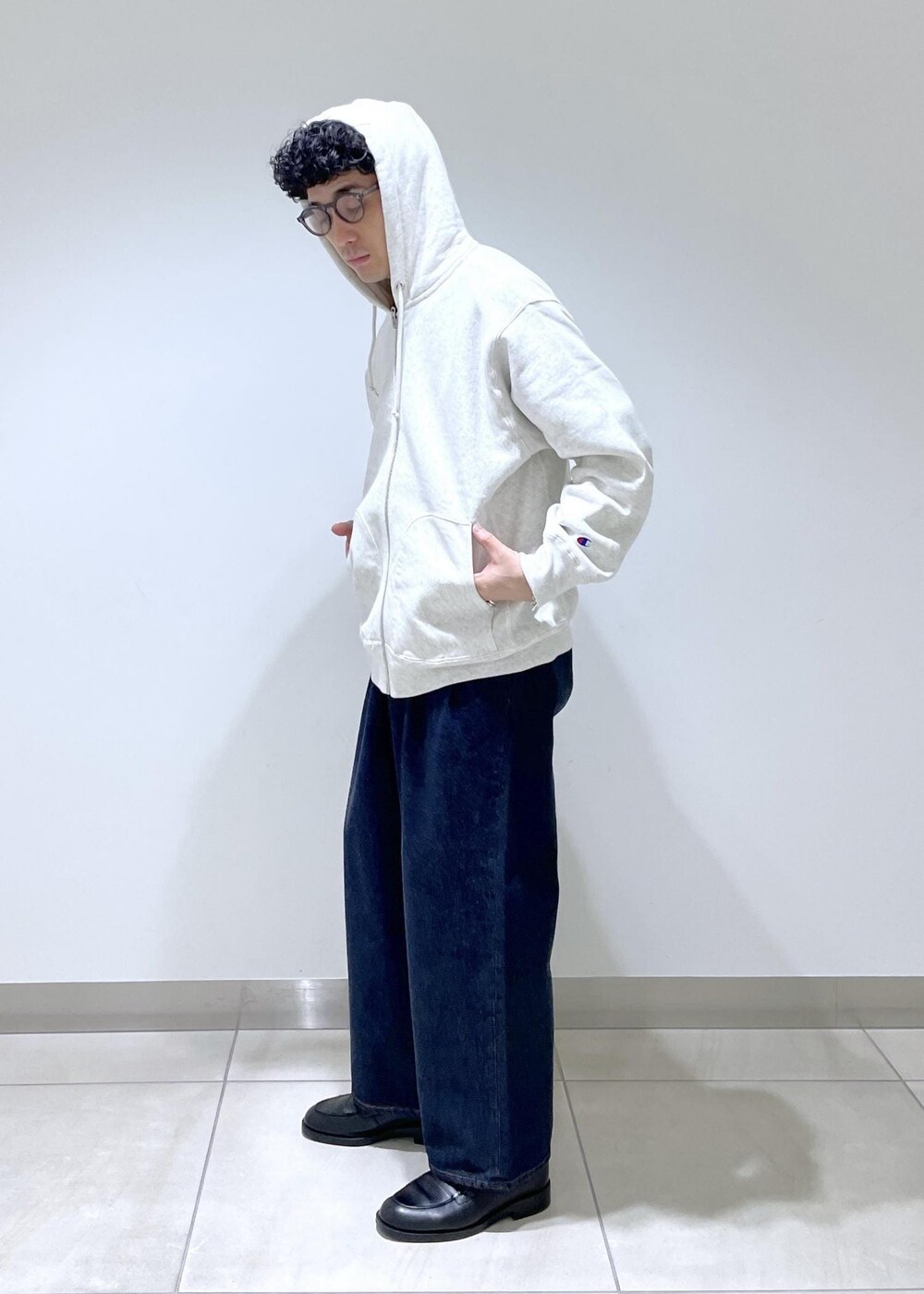 ホワイト系のパーカー、ブルー系のデニムパンツを着用したメンズの冬コーディネートの5枚目の写真