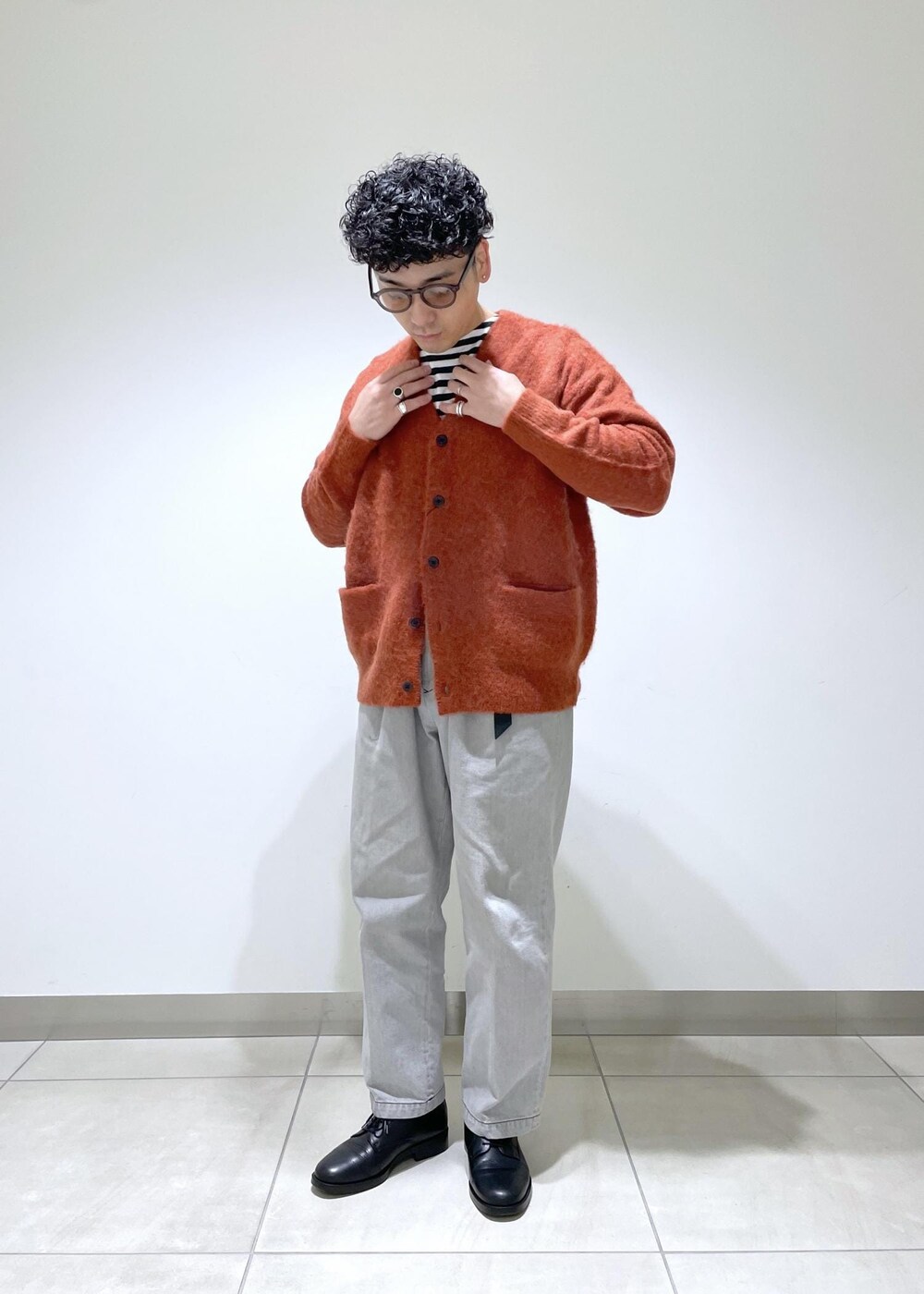 オレンジ系のカーディガン/ボレロを着用したメンズの冬コーディネートの4枚目の写真