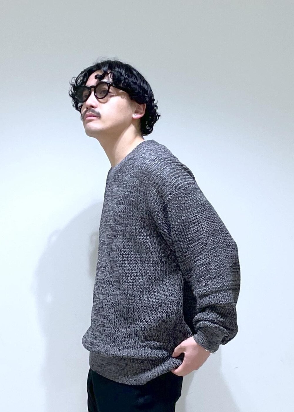 ブラック系のニット/セーター、ブラック系のその他パンツを着用したメンズの春コーディネートの3枚目の写真