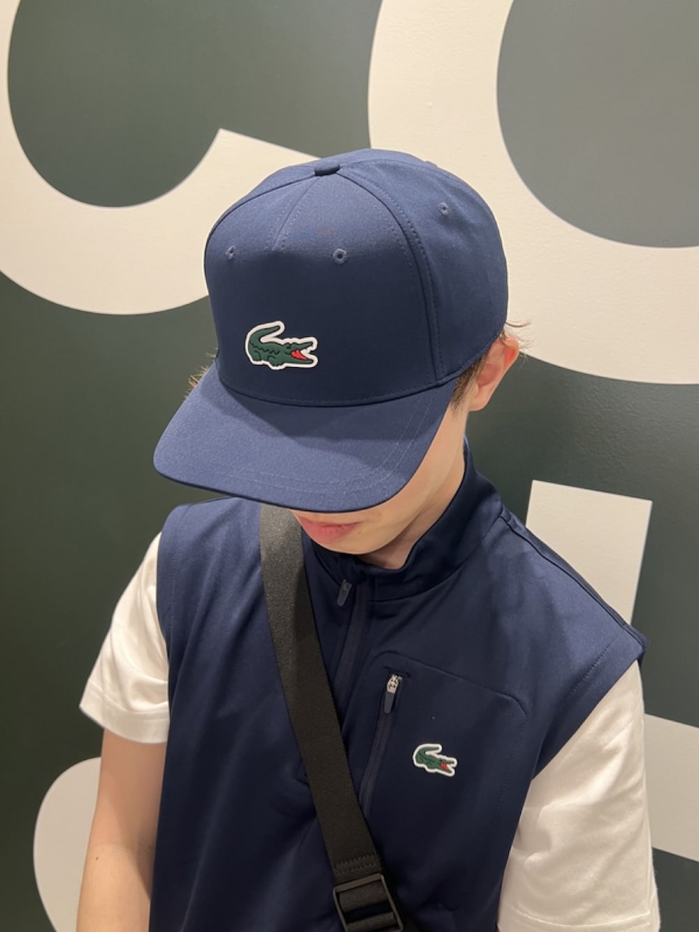 「ベスト、スポーツミックス、キャップ、休日スタイル、スニーカー、ゴルフ、スポーティ、ショートパンツ、Tシャツ、ショルダーバッグ」｜「LACOSTEのワンポイント 耐水ゴルフキャップ（キャップ、ブルー系）」を使った、sakataさん（メンズ・169cm）の春コーディネートの7枚目の写真
