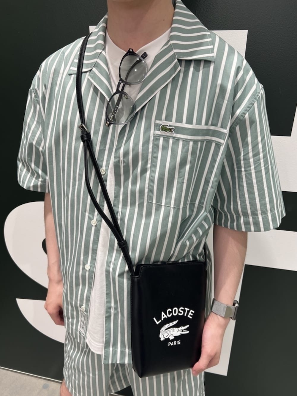「柄シャツ、ショルダーバッグ、サングラス、サンダル、シャツスタイル、白Tシャツ、メンズコーデ、春夏コーデ、リラックススタイル、ストライプシャツ、ストライプ」｜「LACOSTEのアウトラインクロッククルーネック半袖Tシャツ（Tシャツ/カットソー、ホワイト系）」を使った、sakataさん（メンズ・169cm）の春コーディネートの5枚目の写真