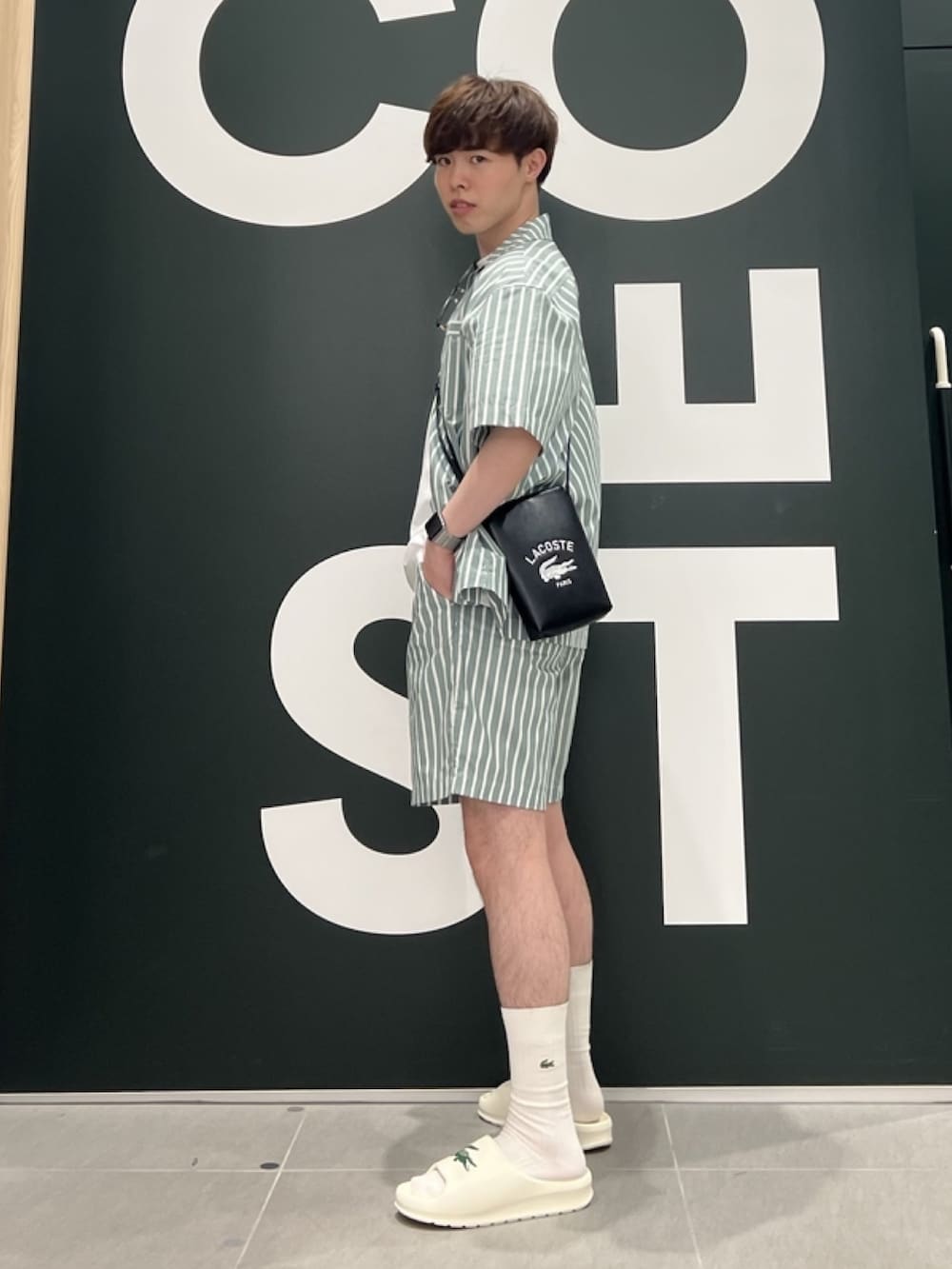「柄シャツ、ショルダーバッグ、サングラス、サンダル、シャツスタイル、白Tシャツ、メンズコーデ、春夏コーデ、リラックススタイル、ストライプシャツ、ストライプ」｜「LACOSTEのアウトラインクロッククルーネック半袖Tシャツ（Tシャツ/カットソー、ホワイト系）」を使った、sakataさん（メンズ・169cm）の春コーディネートの3枚目の写真