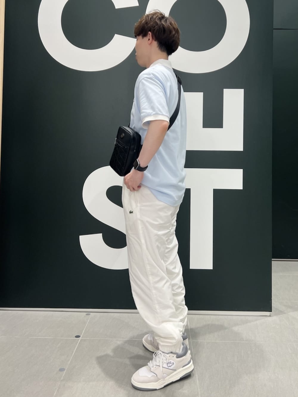 「春コーデ、春めき満開コーデ、スポーツミックス、メンズファッション、春色、春服、ポロシャツ、スニーカー、ショルダーバッグ、レザーバッグ」｜「LACOSTEの耐水透湿トラックパンツ（スウェットパンツ、ホワイト系）」を使った、sakataさん（メンズ・169cm）の春コーディネートの3枚目の写真