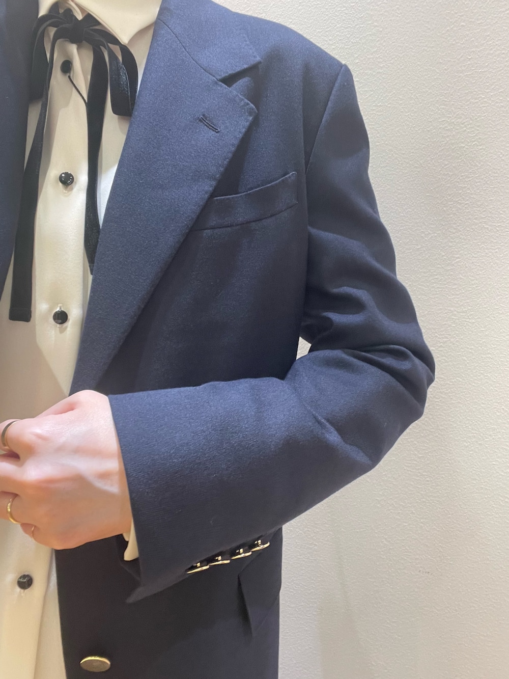 ブルー系のテーラードジャケット、ホワイト系のシャツ/ブラウス、ブラウン系のスカートを着用したレディースの夏コーディネートの7枚目の写真