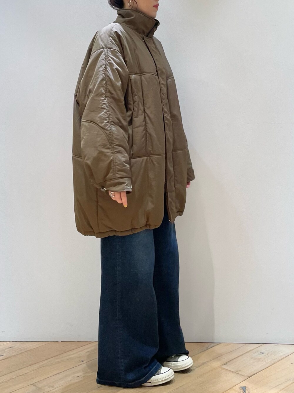 ブラウン系のダウンジャケット/コート、ブラウン系のショルダーバッグ、レッド系のニット/セーターを着用したレディースの冬コーディネートの4枚目の写真