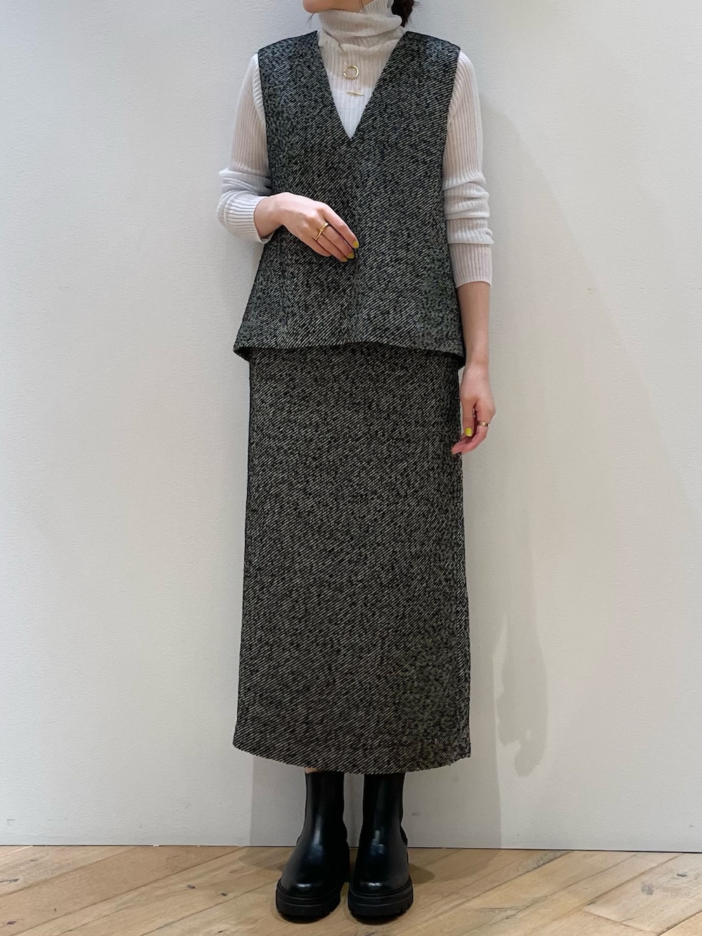 ブラック系のスカート、ブラック系のベスト、グレー系のニット/セーターを着用したレディースの秋コーディネートの4枚目の写真