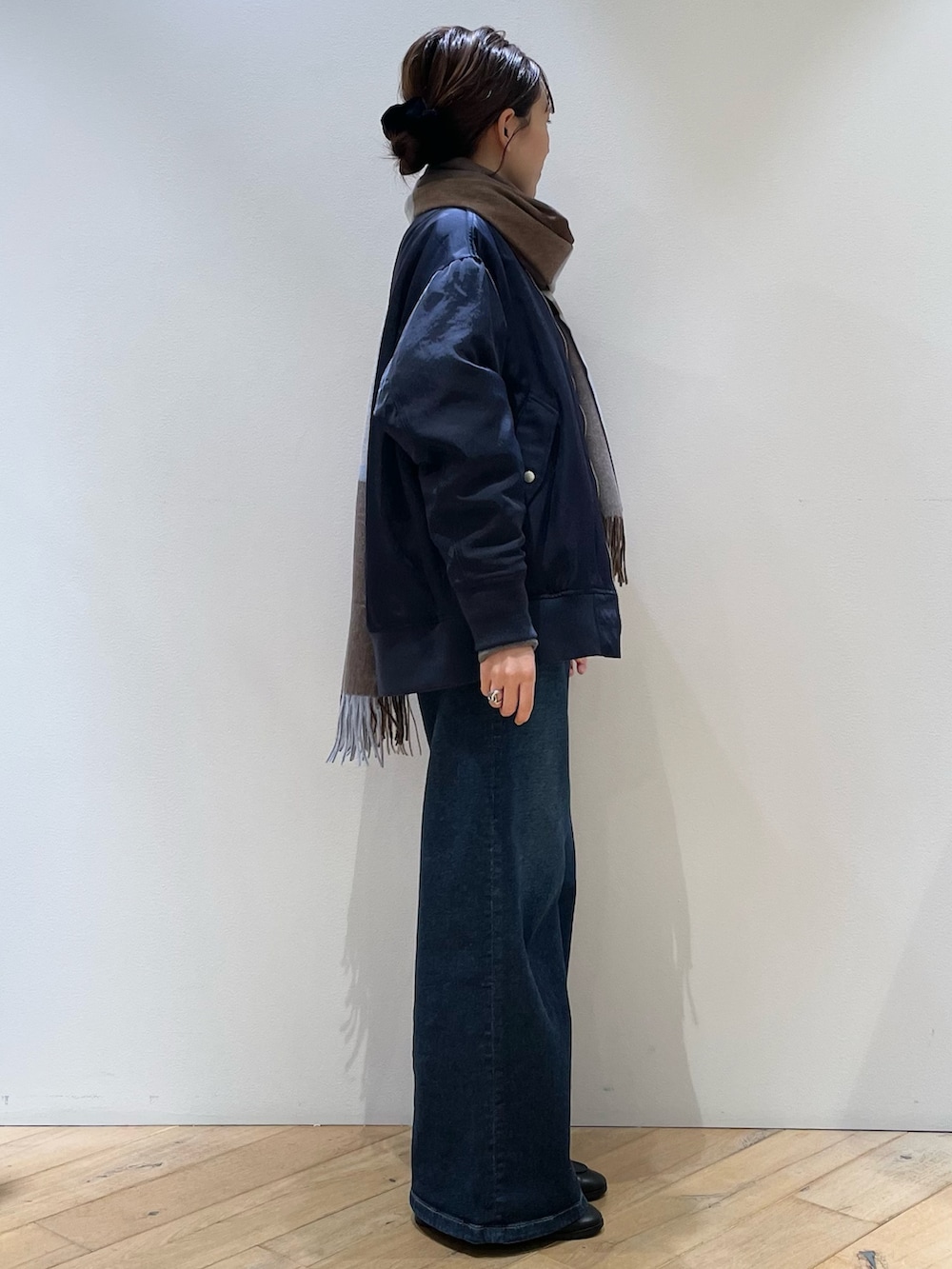 ブラウン系のボストンバッグ、ブラック系のローファー、ブルー系のデニムパンツを着用したレディースの秋コーディネートの4枚目の写真