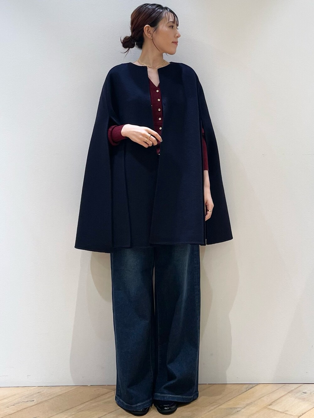 レッド系のニット/セーター、ブルー系のデニムパンツ、ブラック系のローファーを着用したレディースの秋コーディネートの8枚目の写真