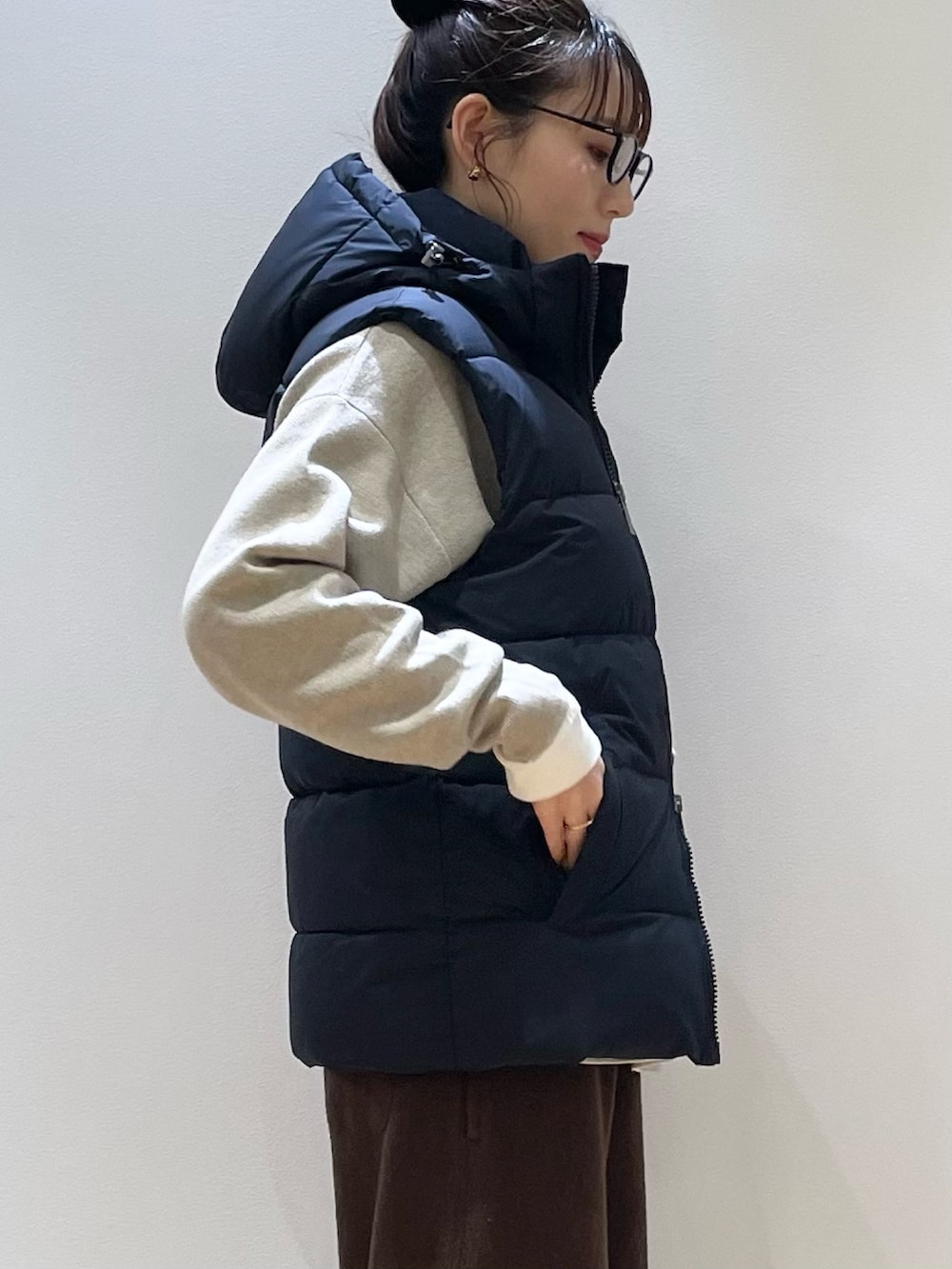 ベージュ系のトートバッグ、ブラウン系のその他パンツ、ベージュ系のニット/セーターを着用したレディースの冬コーディネートの7枚目の写真