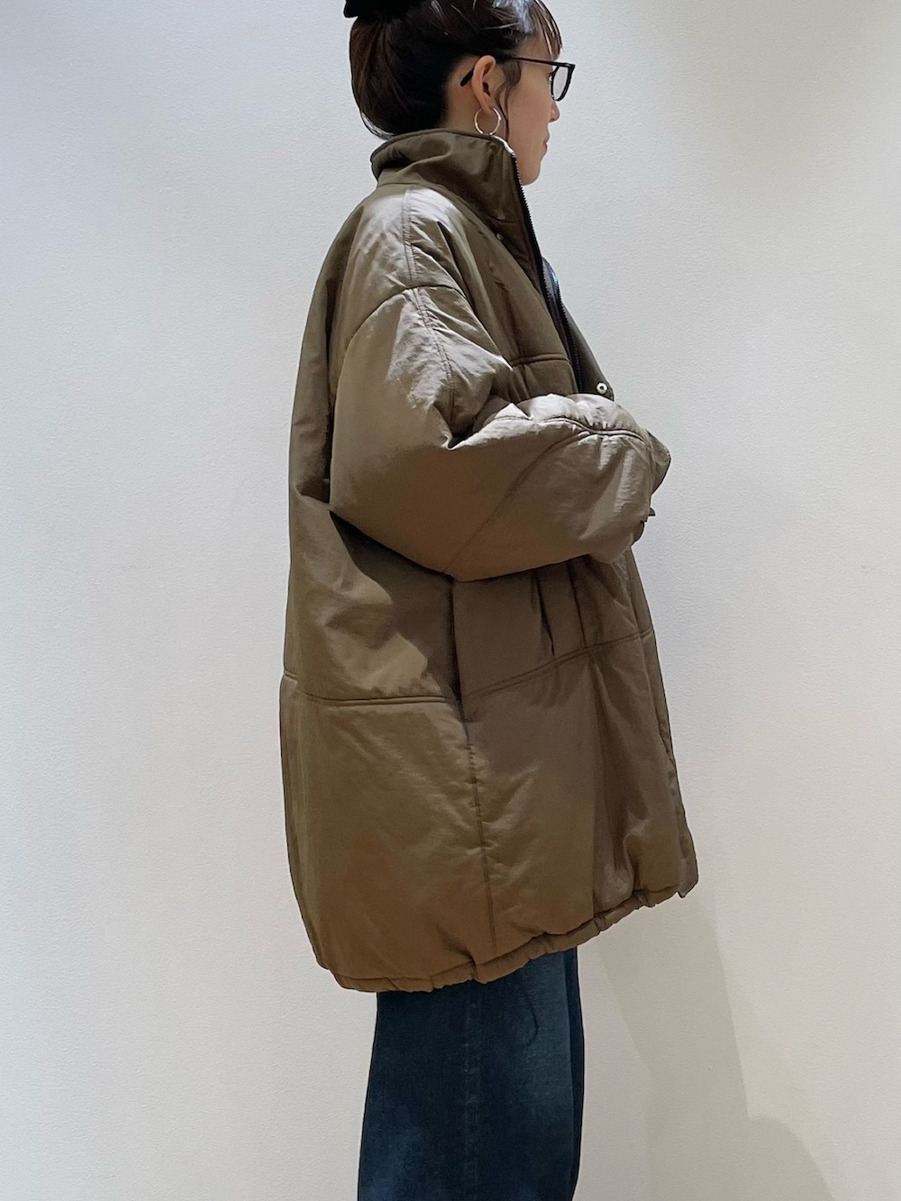 ブラウン系のダウンジャケット/コート、ブラウン系のショルダーバッグ、レッド系のニット/セーターを着用したレディースの冬コーディネートの2枚目の写真