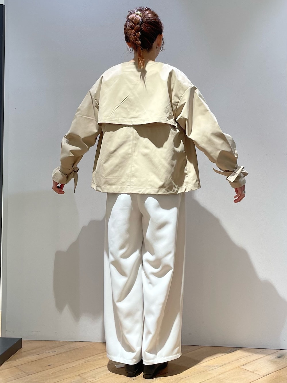 ベージュ系のトレンチコート、ピンク系のニット/セーター、ホワイト系のその他パンツを着用したレディースの春コーディネートの5枚目の写真