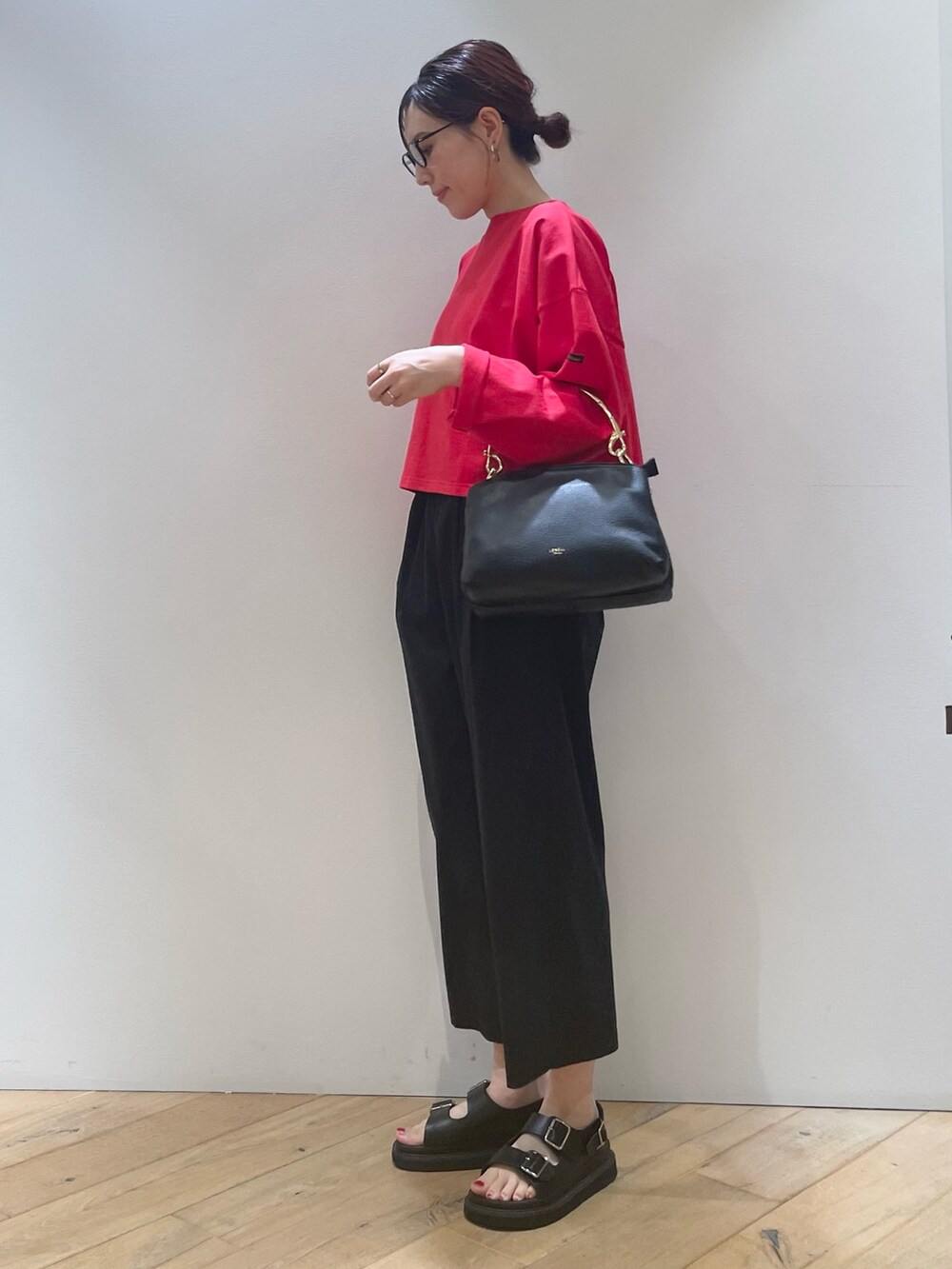 レッド系のTシャツ/カットソー、ブラック系のその他パンツ、ブラック系のショルダーバッグを着用したレディースの夏コーディネートの6枚目の写真