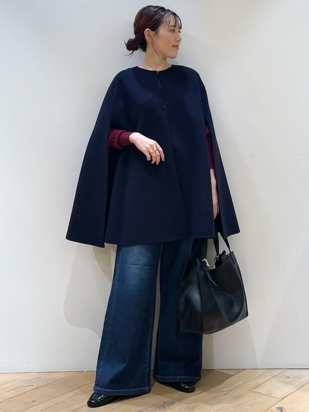 レッド系のニット/セーター、ブルー系のデニムパンツ、ブラック系のローファーを着用したレディースの秋コーディネートの9枚目の写真