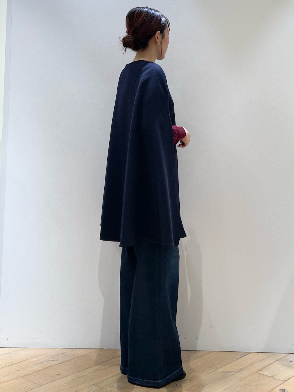 レッド系のニット/セーター、ブルー系のデニムパンツ、ブラック系のローファーを着用したレディースの秋コーディネートの2枚目の写真