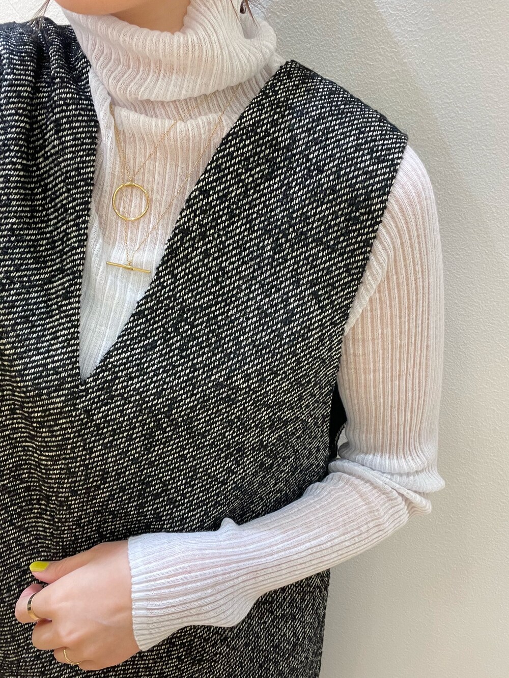 ブラック系のスカート、ブラック系のベスト、グレー系のニット/セーターを着用したレディースの秋コーディネートの7枚目の写真