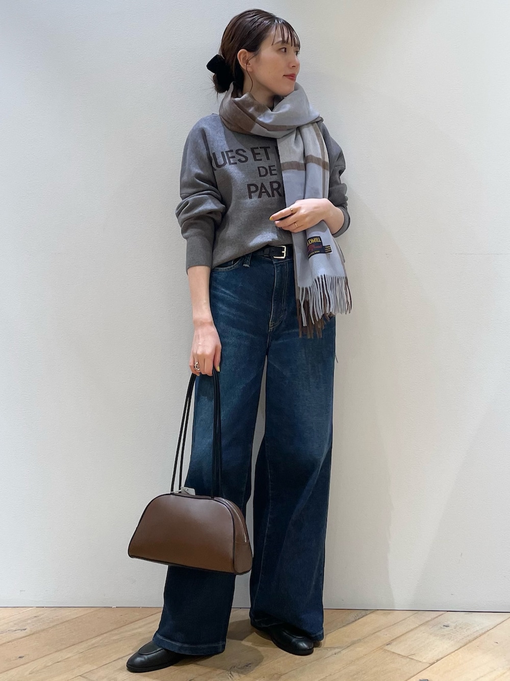 ブラウン系のボストンバッグ、ブラック系のローファー、ブルー系のデニムパンツを着用したレディースの秋コーディネートの8枚目の写真