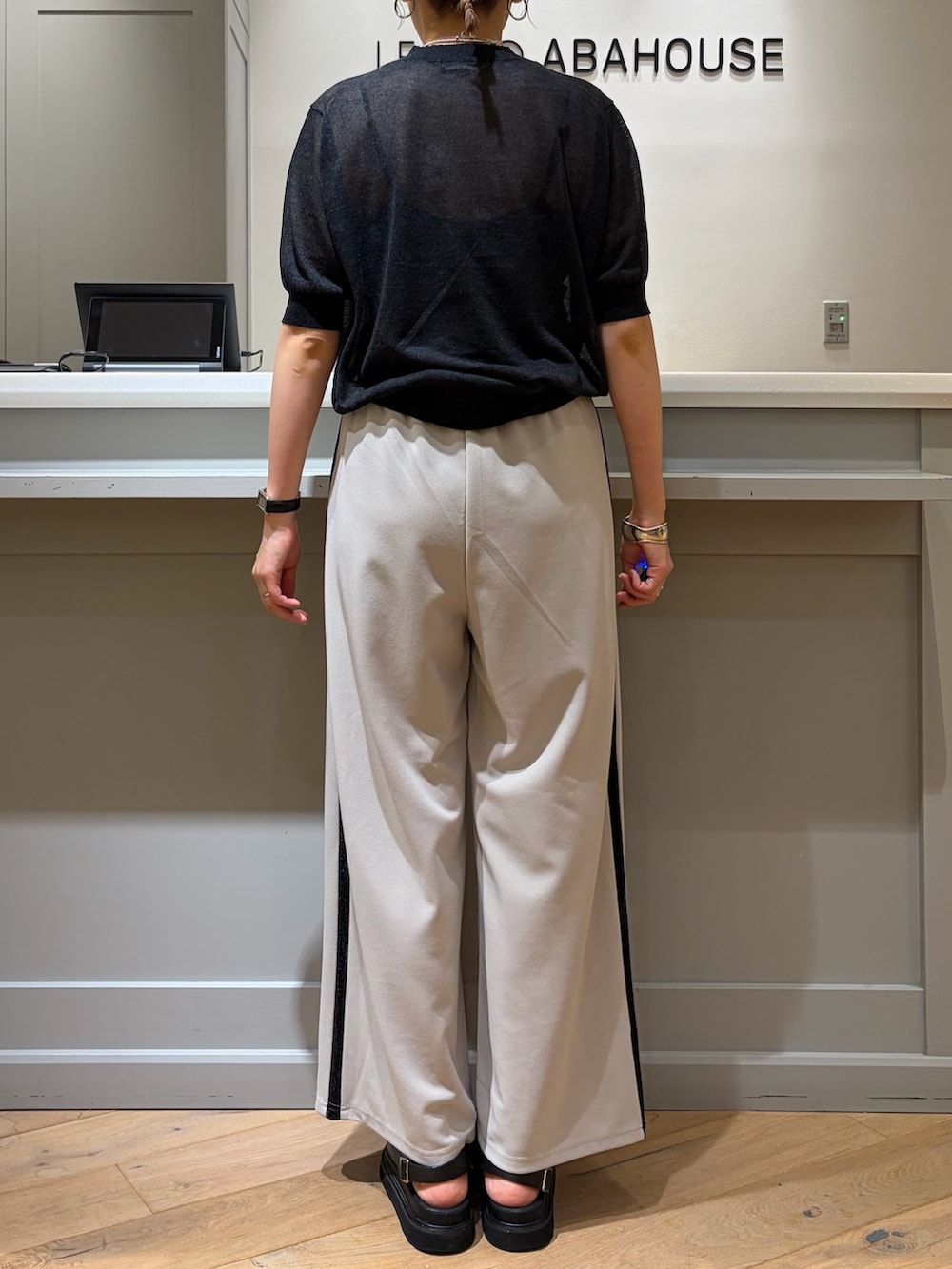 ブラック系のニット/セーター、ベージュ系のその他パンツ、ブラック系のボストンバッグを着用したレディースの夏コーディネートの3枚目の写真