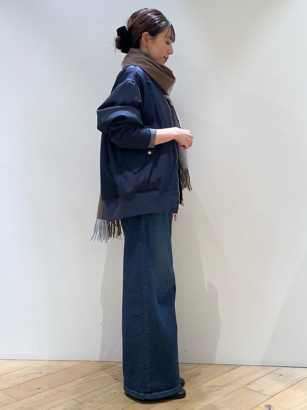 ブラウン系のボストンバッグ、ブラック系のローファー、ブルー系のデニムパンツを着用したレディースの秋コーディネートの2枚目の写真