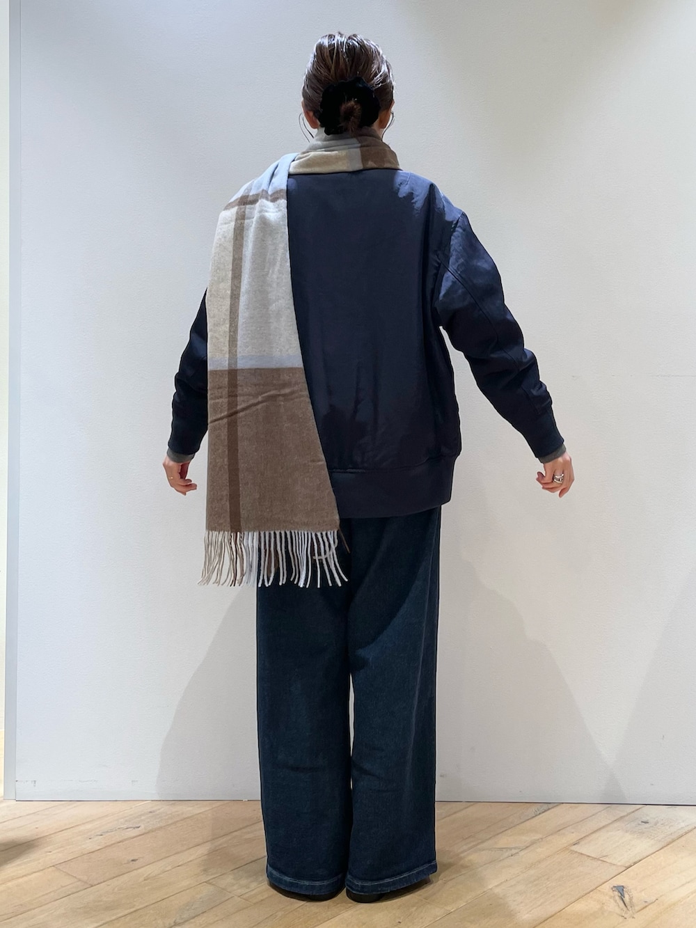 ブラウン系のボストンバッグ、ブラック系のローファー、ブルー系のデニムパンツを着用したレディースの秋コーディネートの6枚目の写真