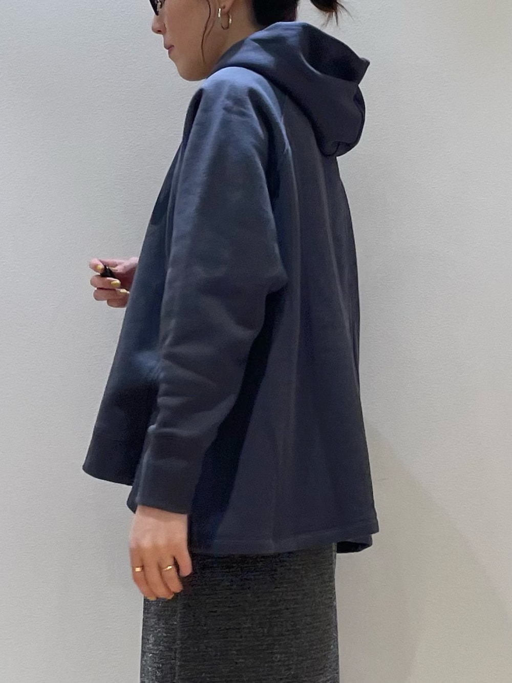 グリーン系のブルゾン、ブルー系のパーカー、シルバー系のスカートを着用したレディースの秋コーディネートの10枚目の写真