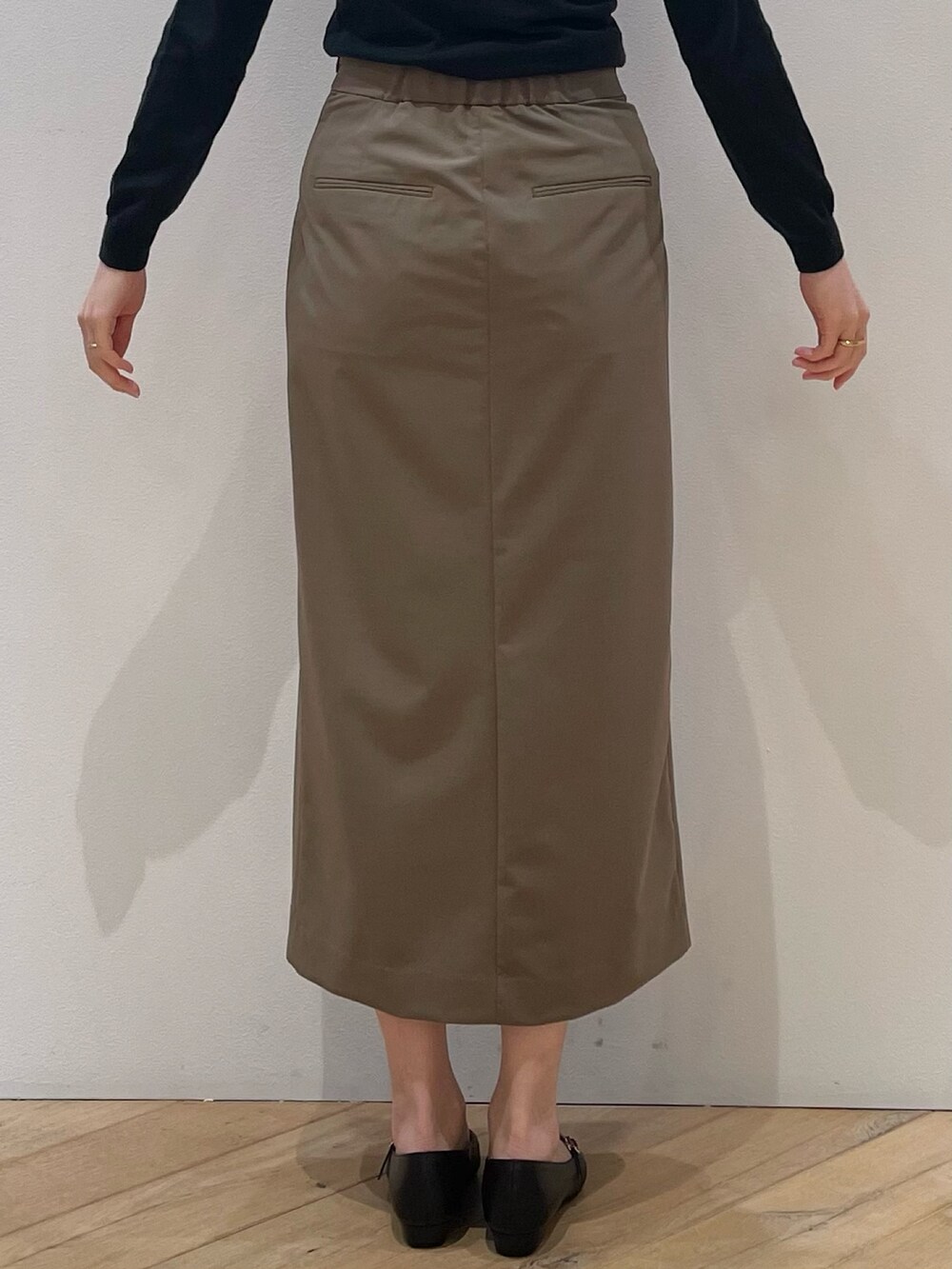 ブラウン系のベスト、ブラック系のパンプス、ブラウン系のスカートを着用したレディースの冬コーディネートの8枚目の写真