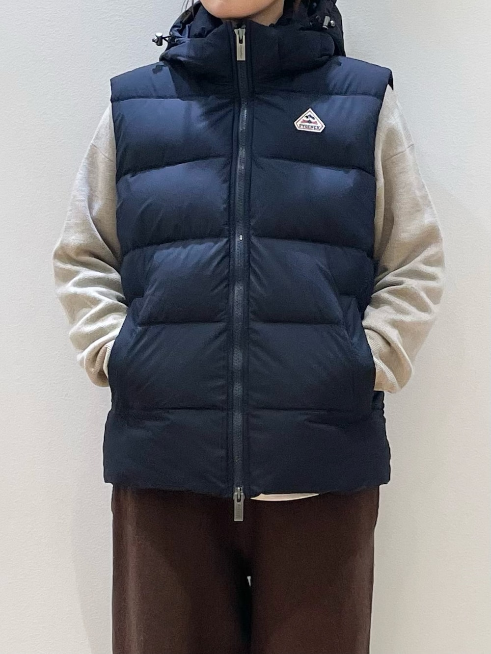 ベージュ系のトートバッグ、ブラウン系のその他パンツ、ベージュ系のニット/セーターを着用したレディースの冬コーディネートの6枚目の写真