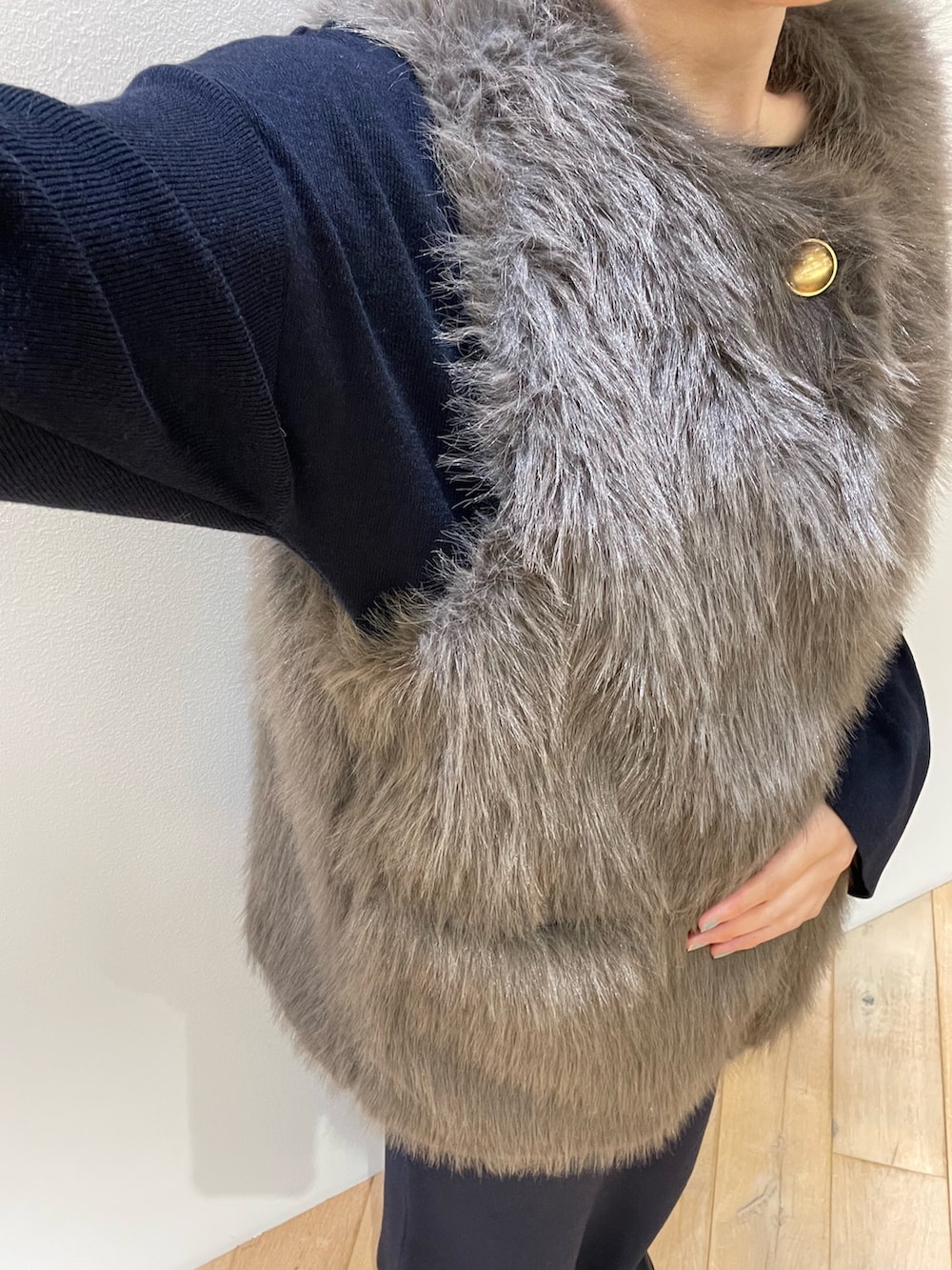 ブラウン系のベスト、ブルー系のニット/セーター、ブルー系のスカートを着用したレディースの秋コーディネートの8枚目の写真