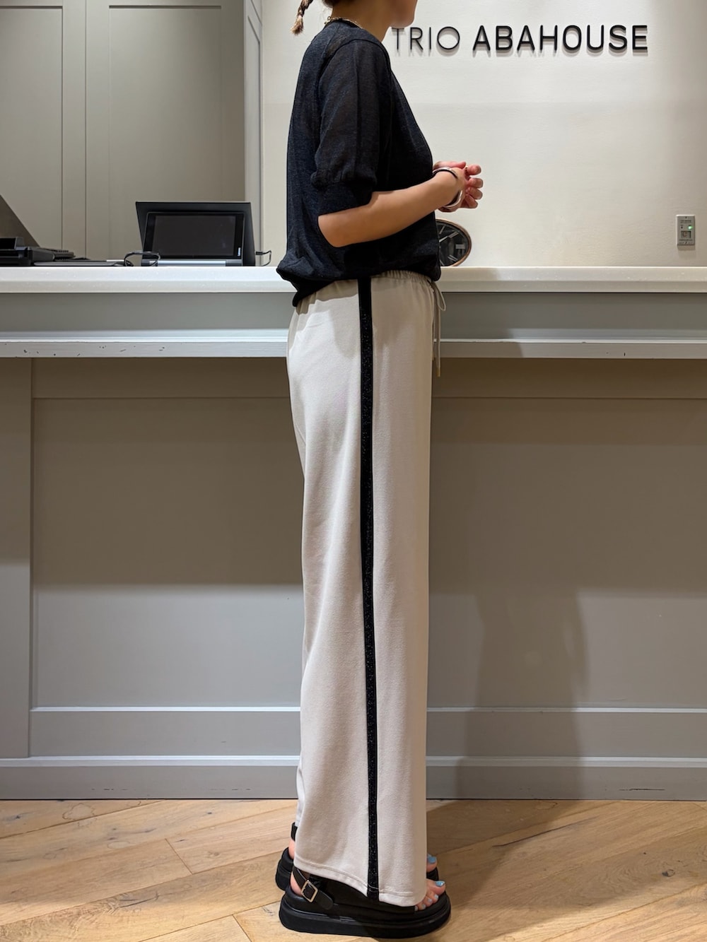 ブラック系のニット/セーター、ベージュ系のその他パンツ、ブラック系のボストンバッグを着用したレディースの夏コーディネートの2枚目の写真