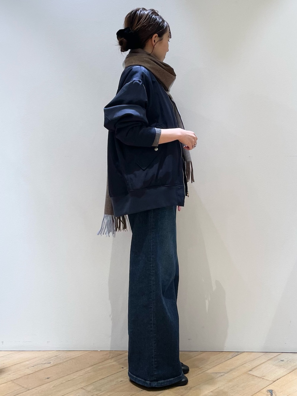 ブラウン系のボストンバッグ、ブラック系のローファー、ブルー系のデニムパンツを着用したレディースの秋コーディネートの3枚目の写真