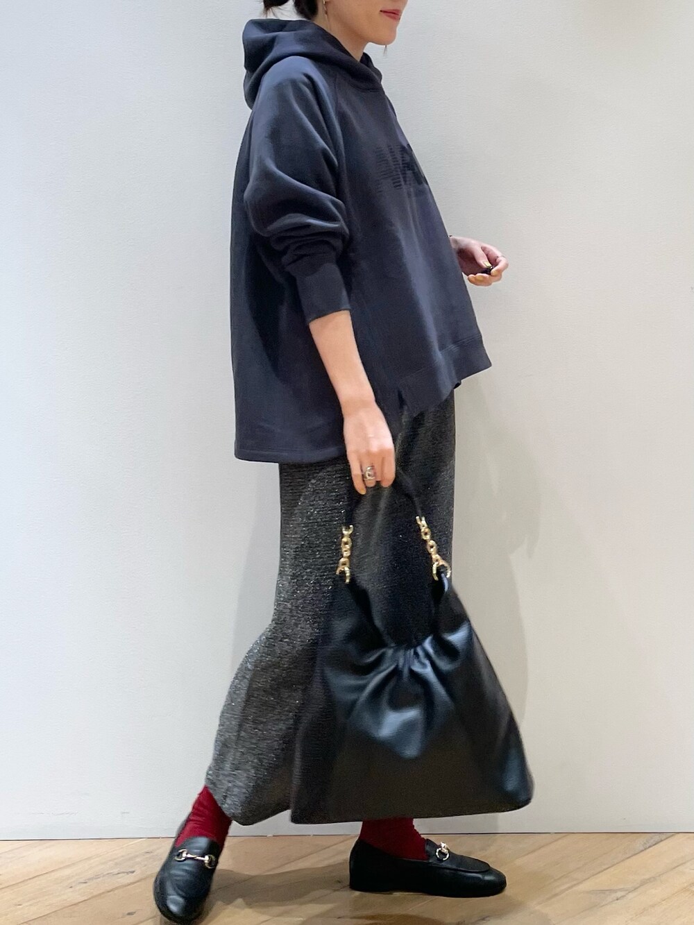 グリーン系のブルゾン、ブルー系のパーカー、シルバー系のスカートを着用したレディースの秋コーディネートの8枚目の写真