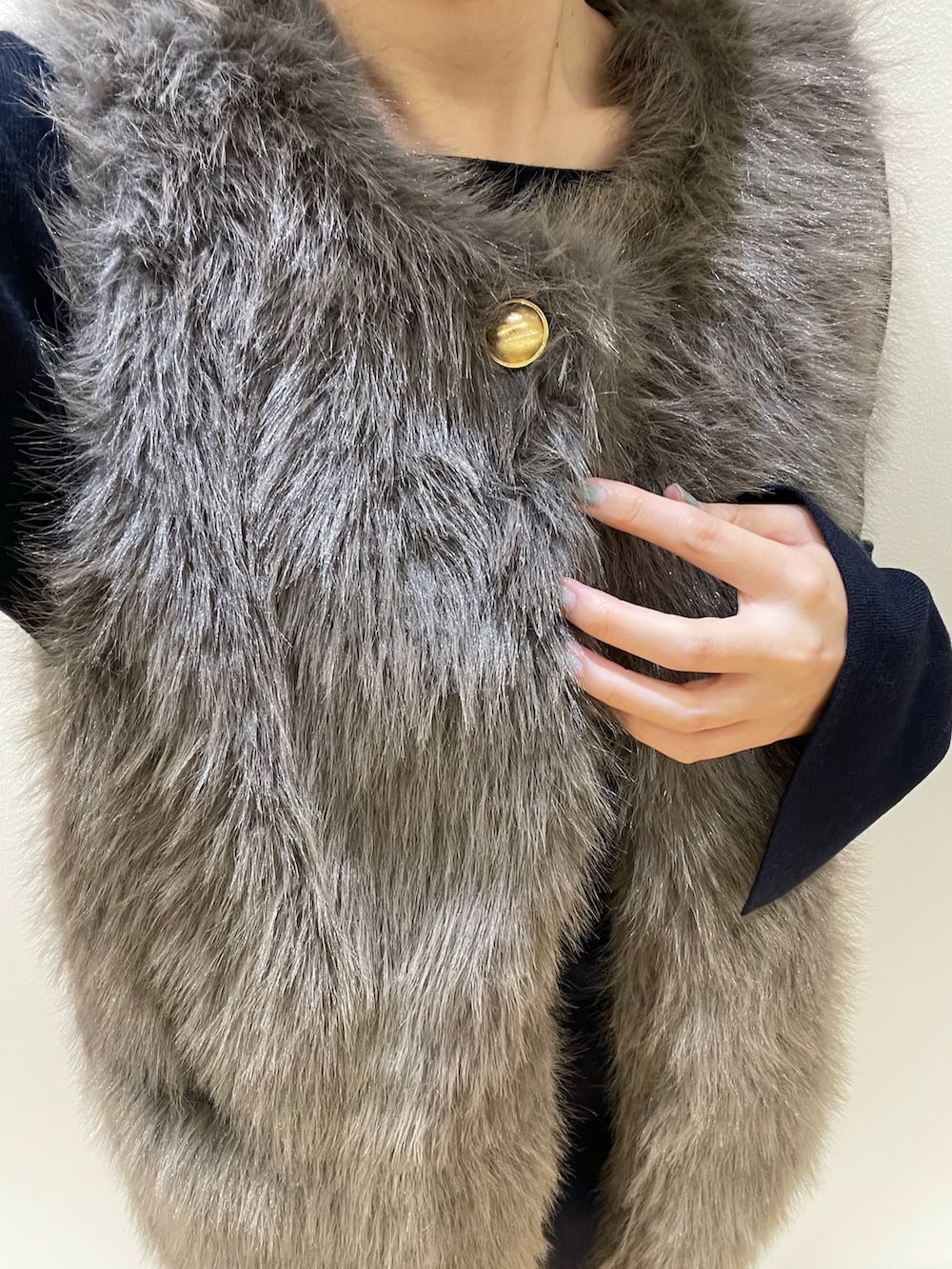 ブラウン系のベスト、ブルー系のニット/セーター、ブルー系のスカートを着用したレディースの秋コーディネートの6枚目の写真