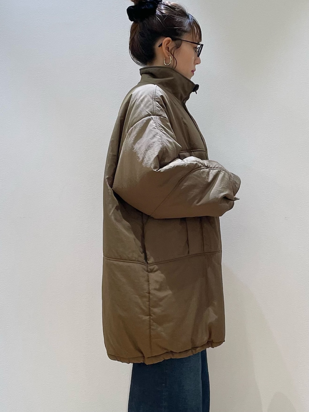 ブラウン系のダウンジャケット/コート、ブラウン系のショルダーバッグ、レッド系のニット/セーターを着用したレディースの冬コーディネートの6枚目の写真