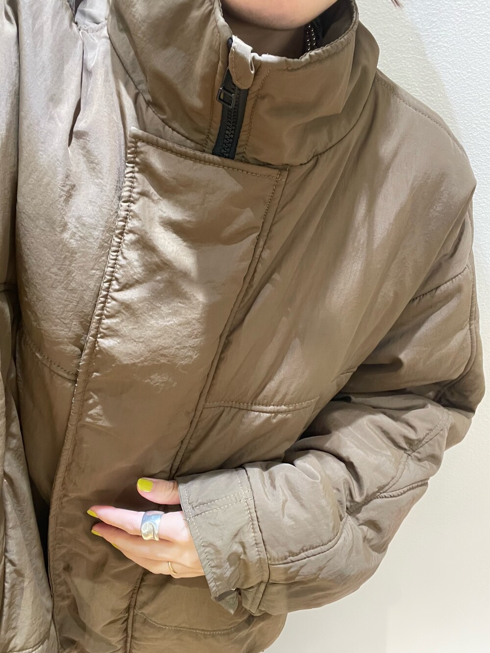 ブラウン系のダウンジャケット/コート、ブラウン系のショルダーバッグ、レッド系のニット/セーターを着用したレディースの冬コーディネートの7枚目の写真