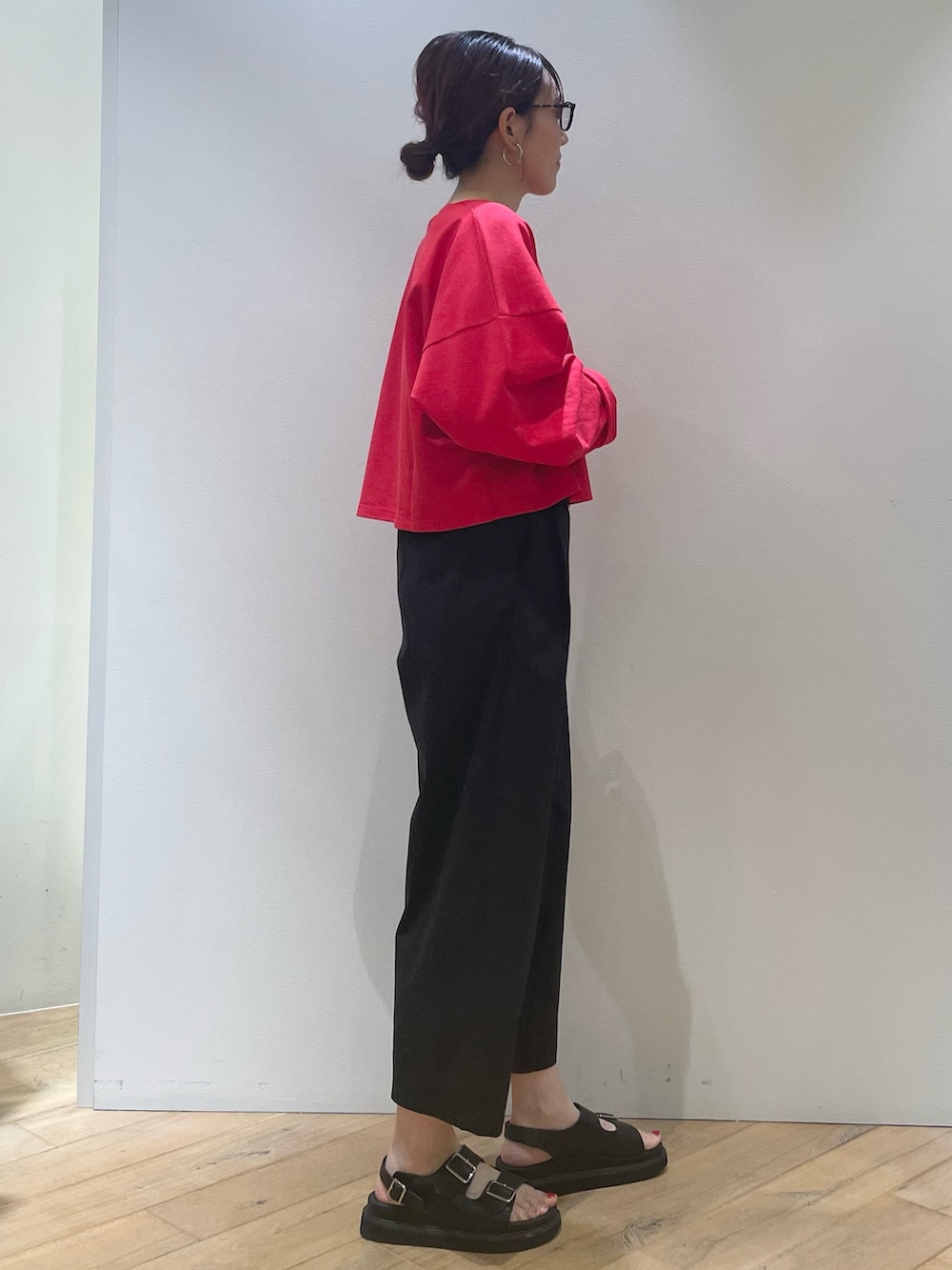 レッド系のTシャツ/カットソー、ブラック系のその他パンツ、ブラック系のショルダーバッグを着用したレディースの夏コーディネートの3枚目の写真